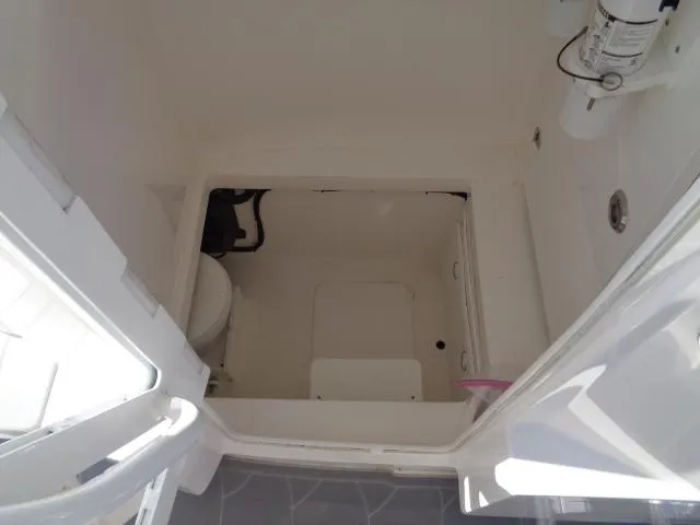 Slide: The Image of 2022 Contender 32 ST boat interior, featuring a compact bathroom with a toilet and storage space. - 10