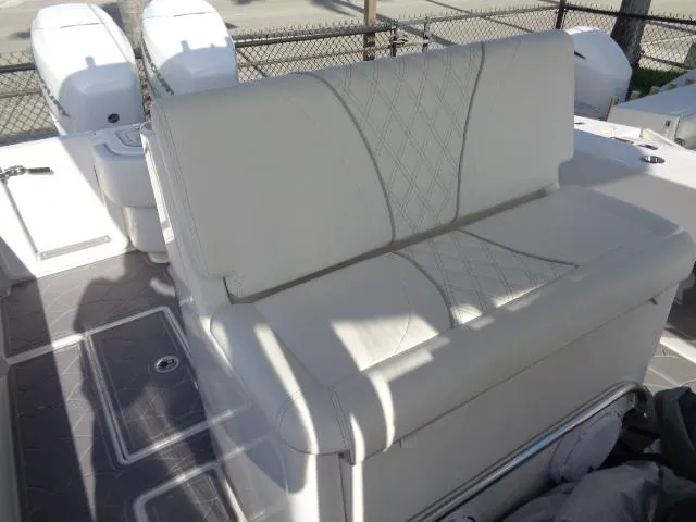 Slide: The Image of 2022 Contender 32 ST boat with white cushioned seating and dual outboard motors. - 18