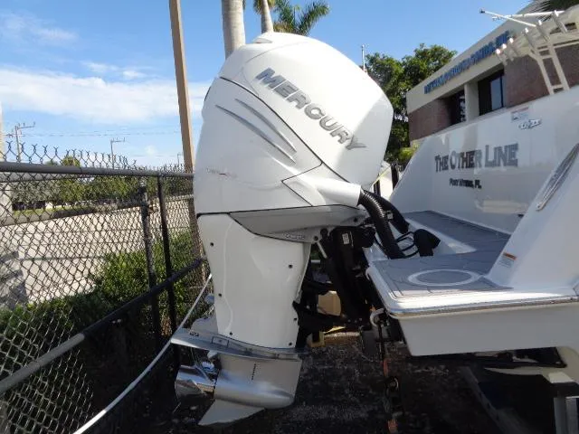 Slide: The Image of 2022 Contender 32 ST boat with Mercury outboard engine, docked near a fence. - 5