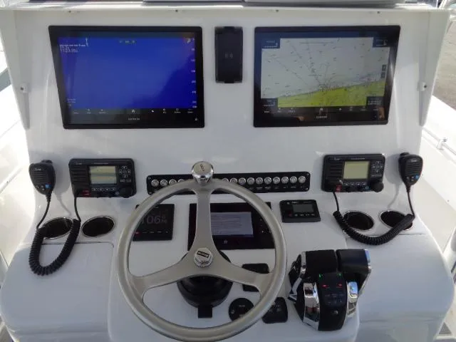 Slide: The Image of Control panel of 2022 Contender 32 ST boat with navigation screens and steering wheel. - 8