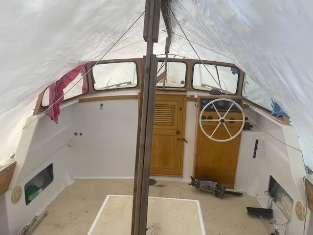 Slide: The Image of 1981 SISU 26 boat interior with wooden steering wheel and covered deck. - 4