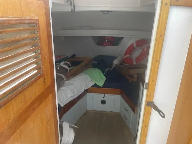 Slide: The Image of 1981 SISU 26 boat cabin interior with wooden door, bed, and life preserver. - 6