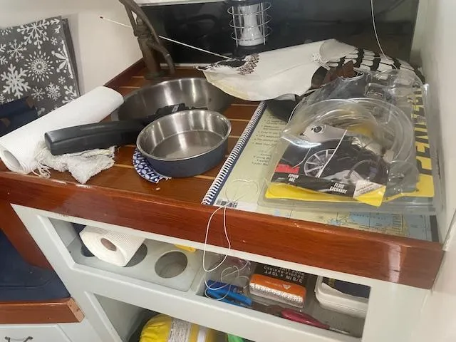 Slide: The Image of Boat interior with kitchen items and storage, featuring a 1981 SISU 26 model. - 7