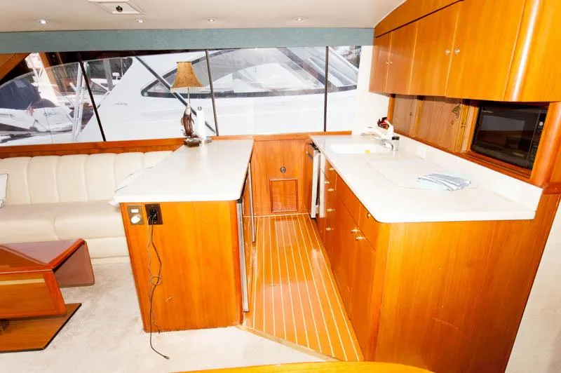 Slide: The Image of Interior of 1997 Ocean Yachts 53 Super Sport with wooden cabinetry and white countertops. - 15