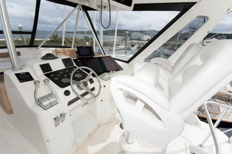 Slide: The Image of 1997 Ocean Yachts 53 Super Sport helm with white seating and modern controls. - 22