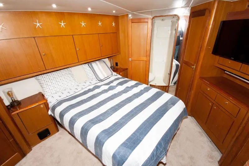 Slide: The Image of Luxurious cabin interior of 1997 Ocean Yachts 53 Super Sport with striped bedding. - 9