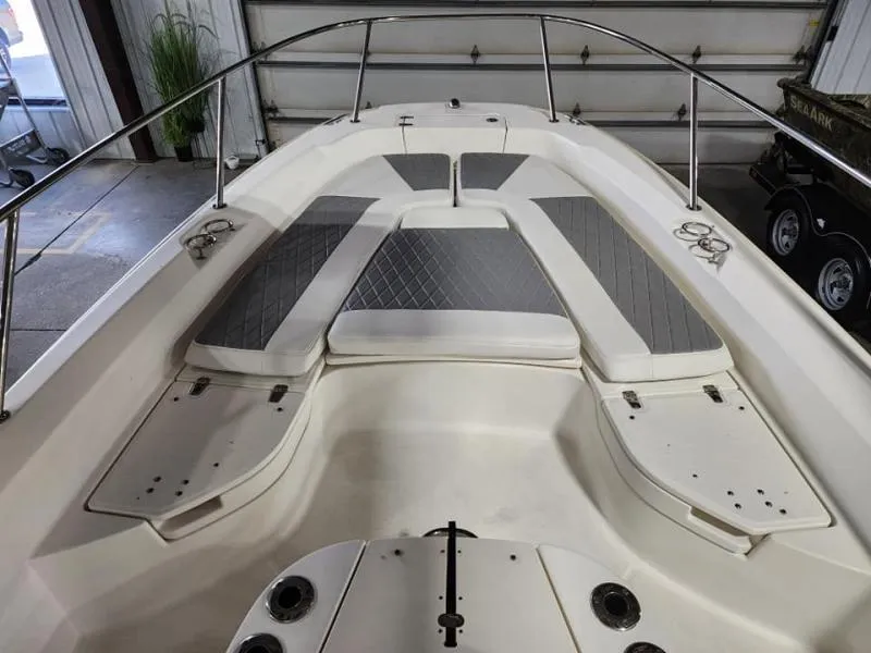 Slide: The Image of 2015 Boston Whaler 240 Dauntless boat interior with cushioned seating and stainless steel railings. - 3