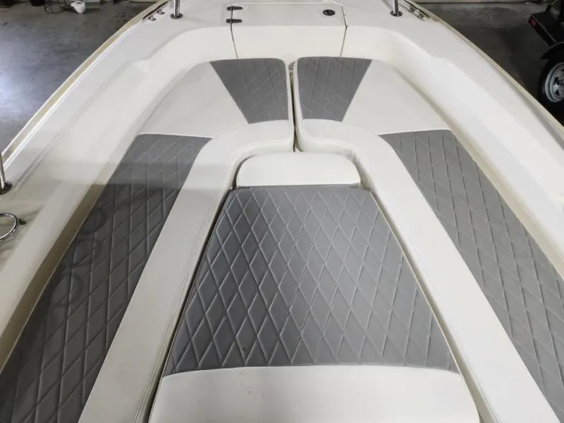 Slide: The Image of 2015 Boston Whaler 240 Dauntless boat interior with gray and white cushioned seating. - 7