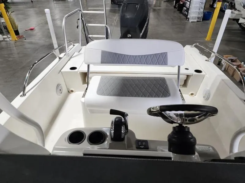 Slide: The Image of 2015 Boston Whaler 240 Dauntless boat interior with steering wheel and seating. - 9