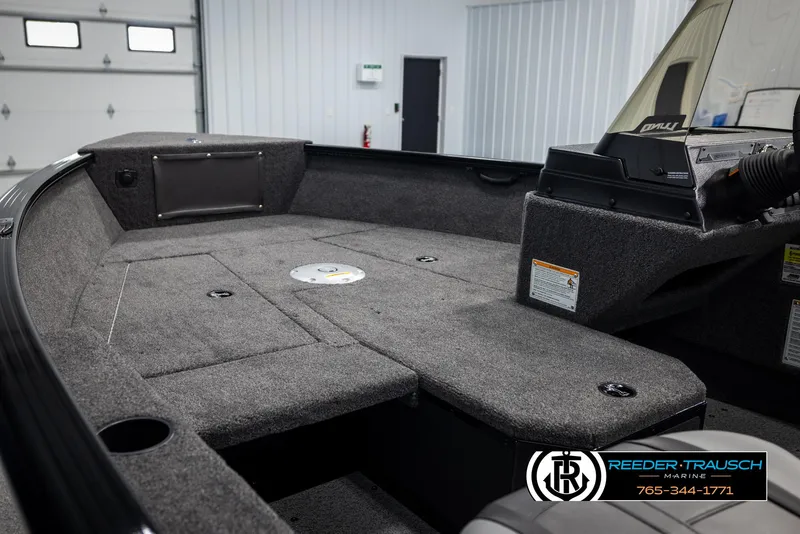 Slide: The Image of 2025 Lund Adventure SS boat interior with carpeted deck and console, in showroom setting. - 15