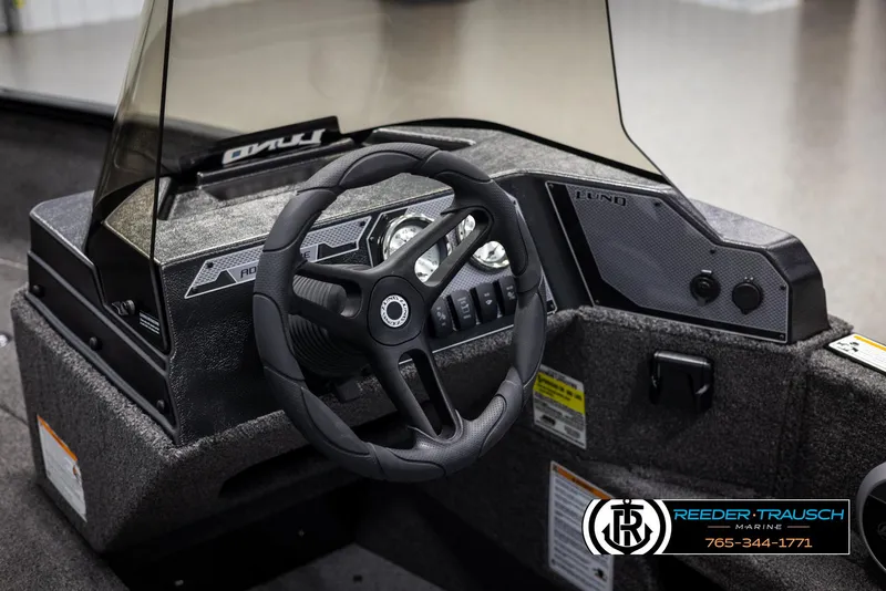 Slide: The Image of 2025 Lund Adventure SS boat dashboard with steering wheel and control panel. - 19