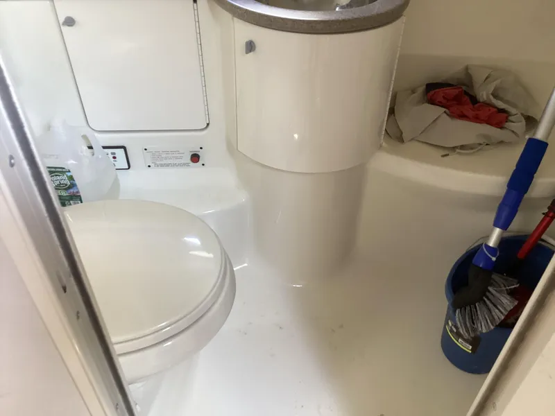 Slide: The Image of Bathroom interior of 2001 Formula 370 Super Sport boat, featuring toilet and cleaning supplies. - 20