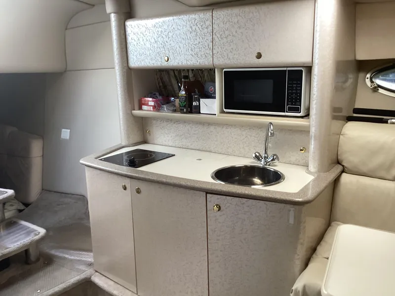 Slide: The Image of 2001 Formula 370 Super Sport boat interior kitchen with sink, stove, and microwave. - 21