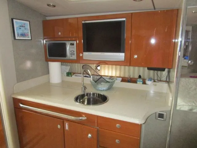 Slide: The Image of 2006 Formula 34 PC yacht kitchen with sink, microwave, and TV. - 13