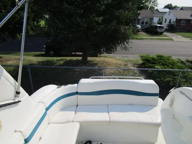 Slide: The Image of 2006 Formula 34 PC boat with white and blue seating, parked near a residential area. - 8