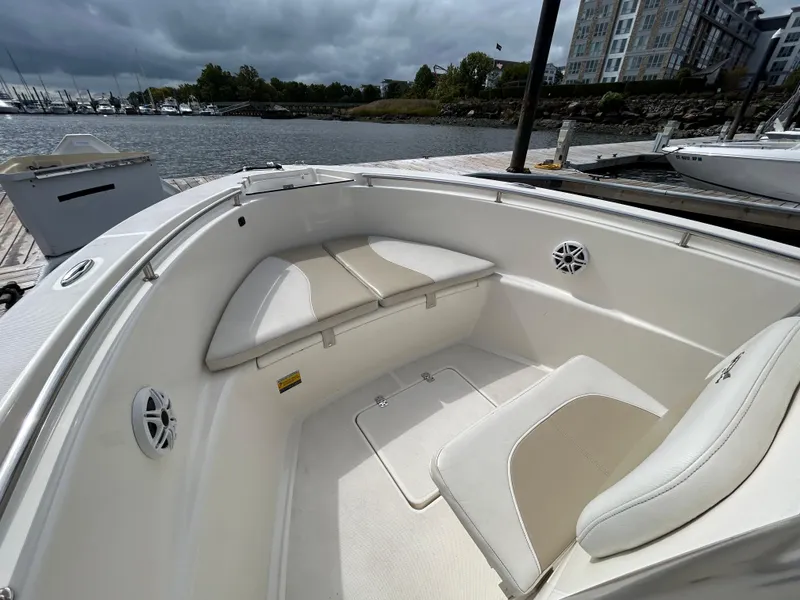 Slide: The Image of 2021 Bulls Bay 230 Center Console boat interior at dock, featuring cushioned seating. - 17
