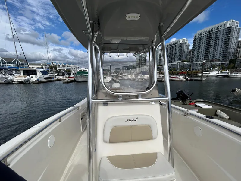 Slide: The Image of 2021 Bulls Bay 230 Center Console boat docked in a marina with city skyline. - 21