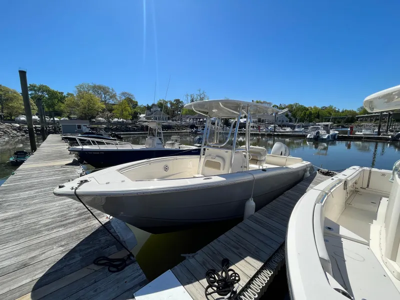 Slide: The Image of 2021 Bulls Bay 230 Center Console boat docked at a marina under clear blue skies. - 22