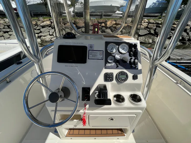 Slide: The Image of 2021 Bulls Bay 230 Center Console boat dashboard with steering wheel and gauges. - 23