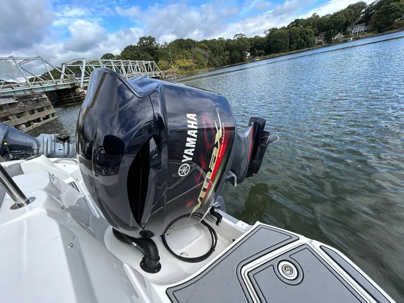 Slide: The Image of NauticStar 243 DC 2021 boat with Yamaha outboard motor on a calm lake. - 10