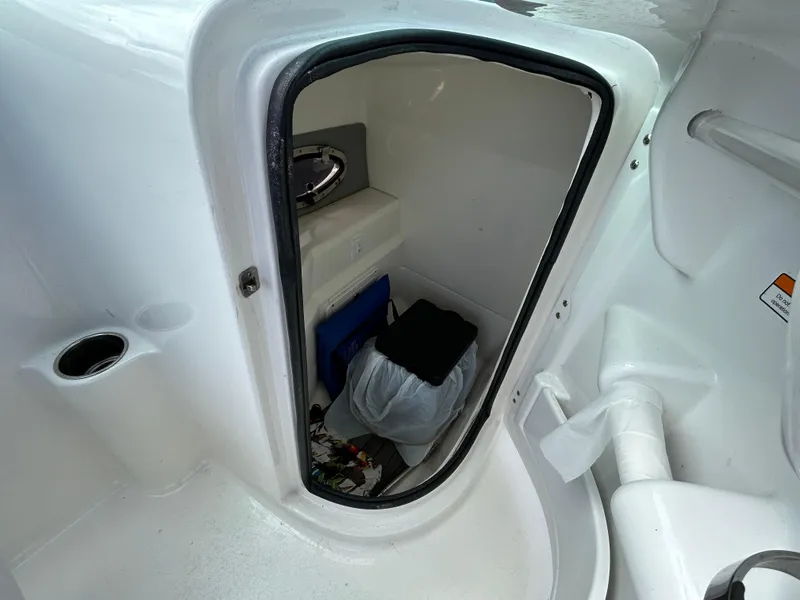 Slide: The Image of 2021 NauticStar 243 DC boat storage compartment with various items inside. - 16