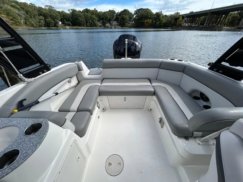Slide: The Image of 2021 NauticStar 243 DC boat interior with spacious seating on a calm lake. - 18
