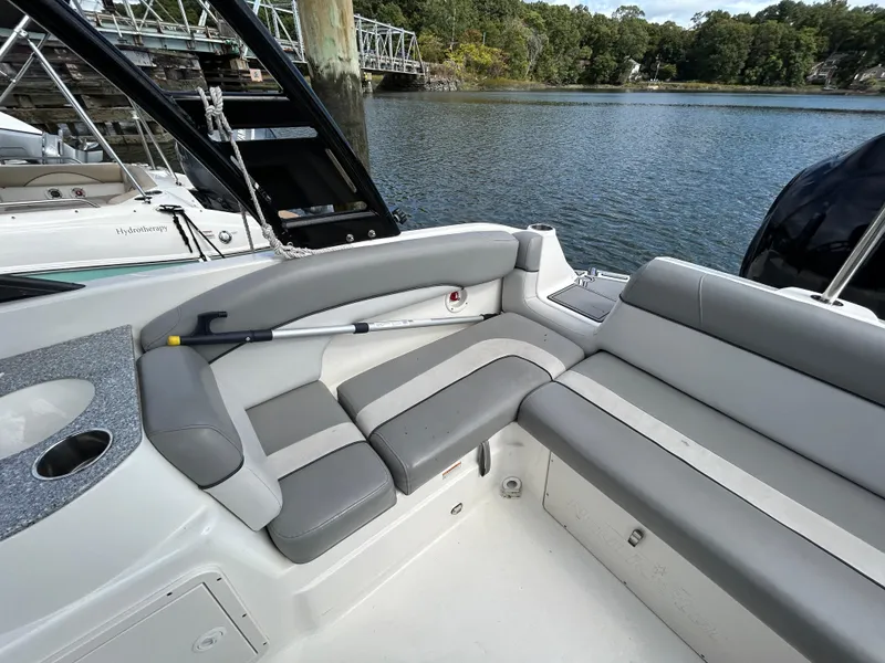 Slide: The Image of 2021 NauticStar 243 DC boat interior with gray seating by the water. - 19