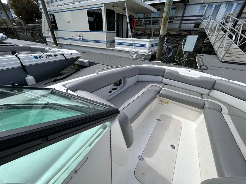 Slide: The Image of 2021 NauticStar 243 DC boat with spacious seating at a marina dock. - 21