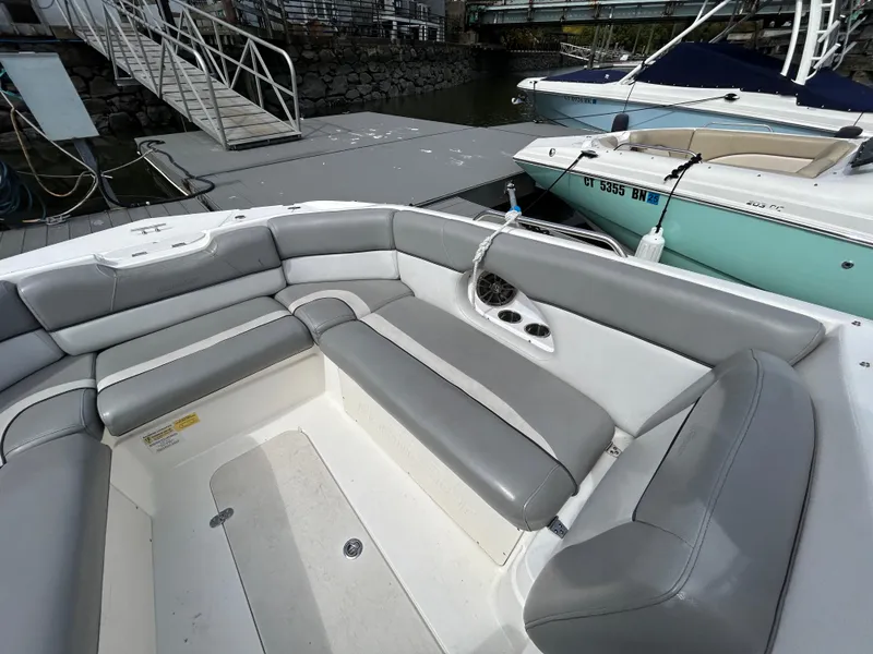 Slide: The Image of 2021 NauticStar 243 DC boat with gray seating at a marina dock. - 22