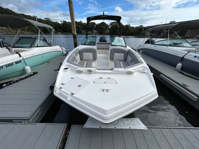 Slide: The Image of 2021 NauticStar 243 DC boat docked between two others on a calm lake. - 3