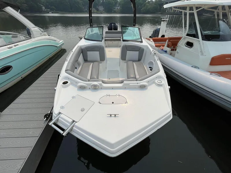 Slide: The Image of 2021 NauticStar 243 DC boat docked on calm water, featuring spacious seating. - 4