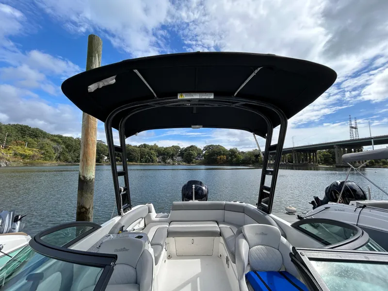 Slide: The Image of 2021 NauticStar 243 DC boat with canopy on a calm river. - 5