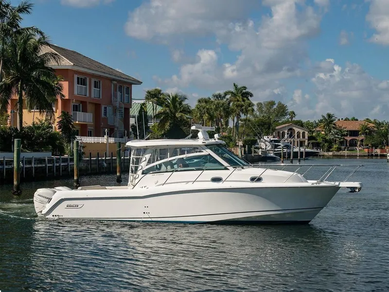 Slide: The Image of 2017 Boston Whaler 345 Conquest boat cruising near waterfront homes. - 1