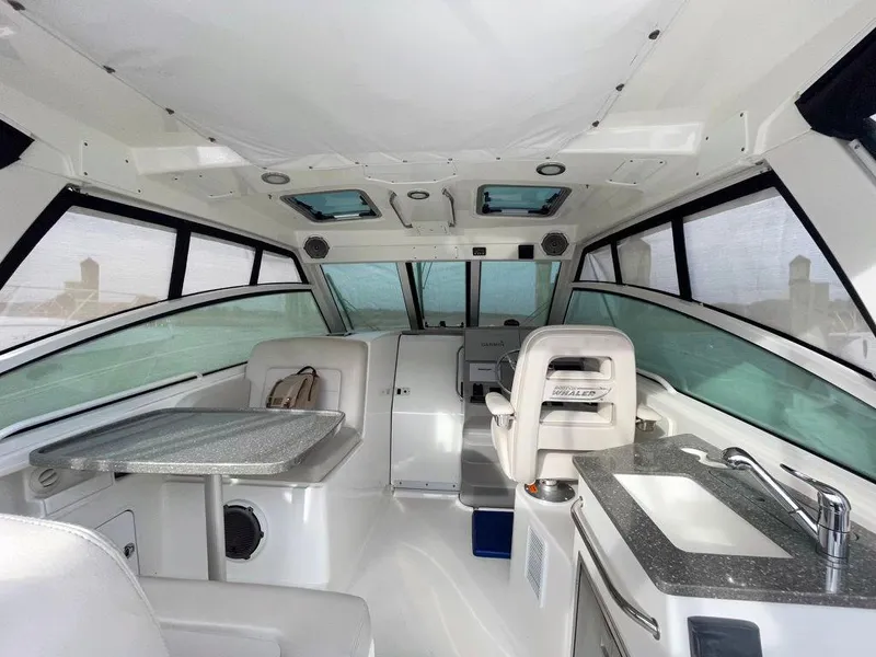Slide: The Image of Interior of 2017 Boston Whaler 345 Conquest boat with seating and kitchenette. - 11