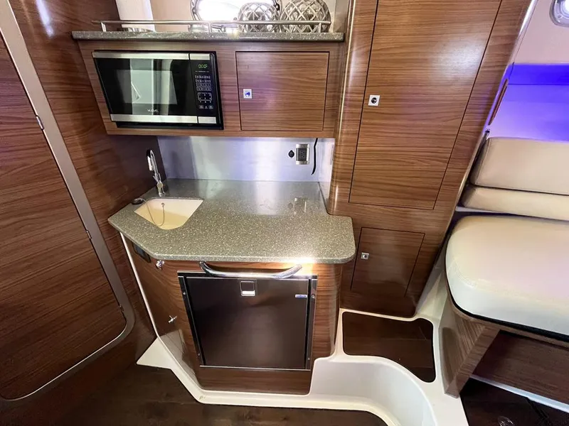 Slide: The Image of 2017 Boston Whaler 345 Conquest interior kitchen with microwave, sink, and fridge. - 23