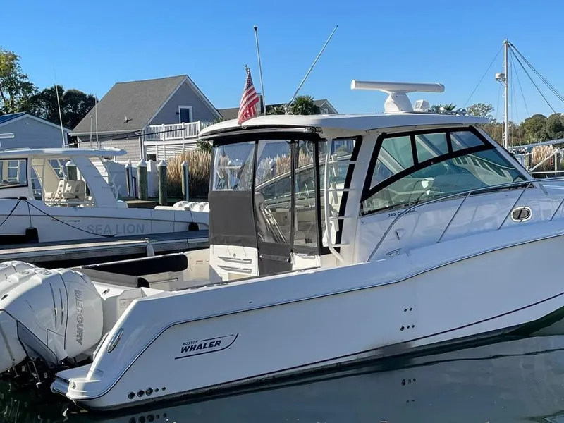 Slide: The Image of 2017 Boston Whaler 345 Conquest boat docked in marina, clear sky background. - 5