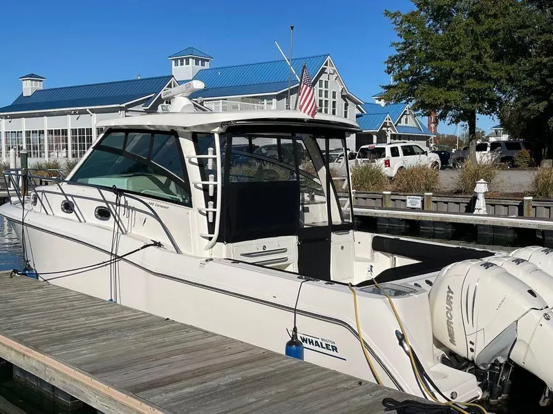 Slide: The Image of 2017 Boston Whaler 345 Conquest docked at marina with blue-roofed buildings. - 6