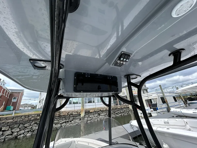Slide: The Image of 2021 NauticStar 2302 Legacy boat console with overhead electronics and controls. - 14