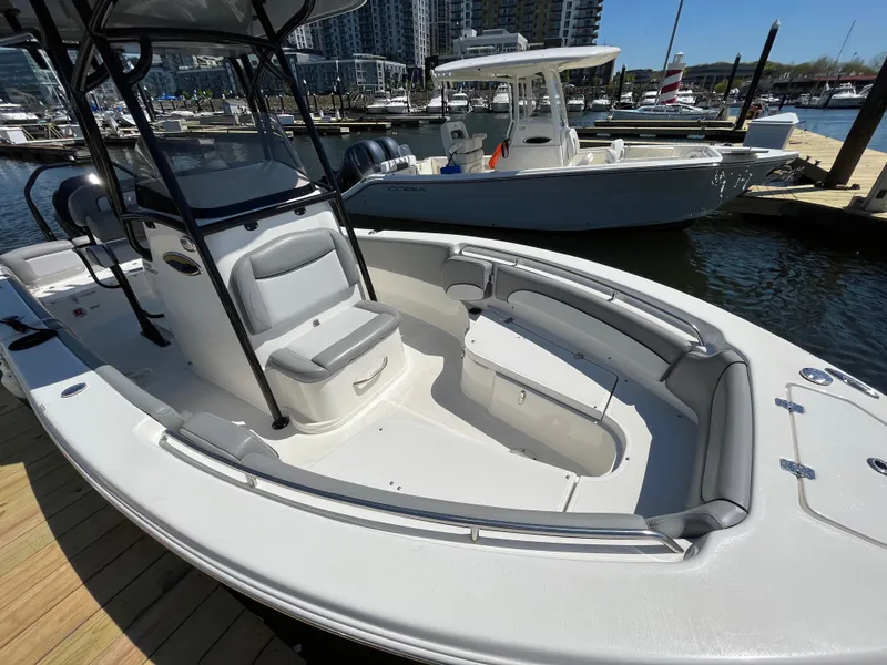 Slide: The Image of 2021 NauticStar 2302 Legacy boat docked at marina, featuring spacious seating and sleek design. - 20