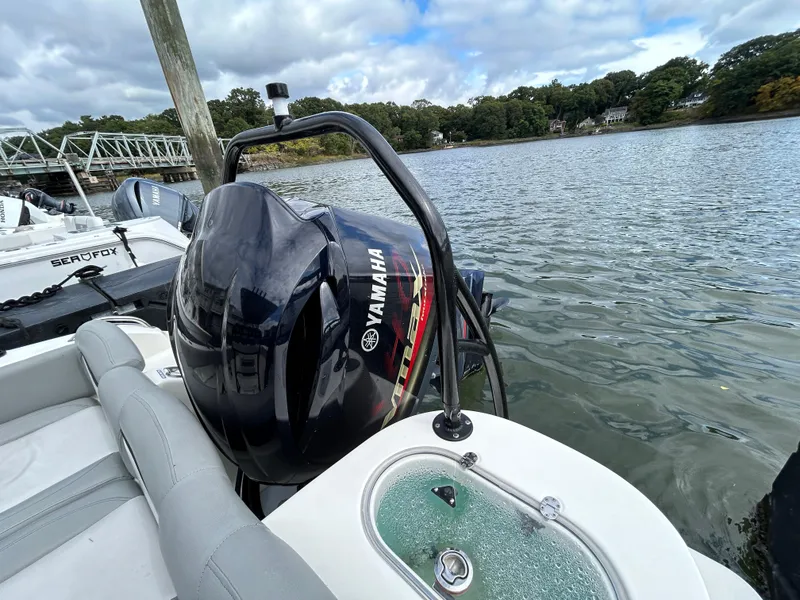 Slide: The Image of 2021 NauticStar 2302 Legacy with Yamaha outboard motor on a calm lake. - 7