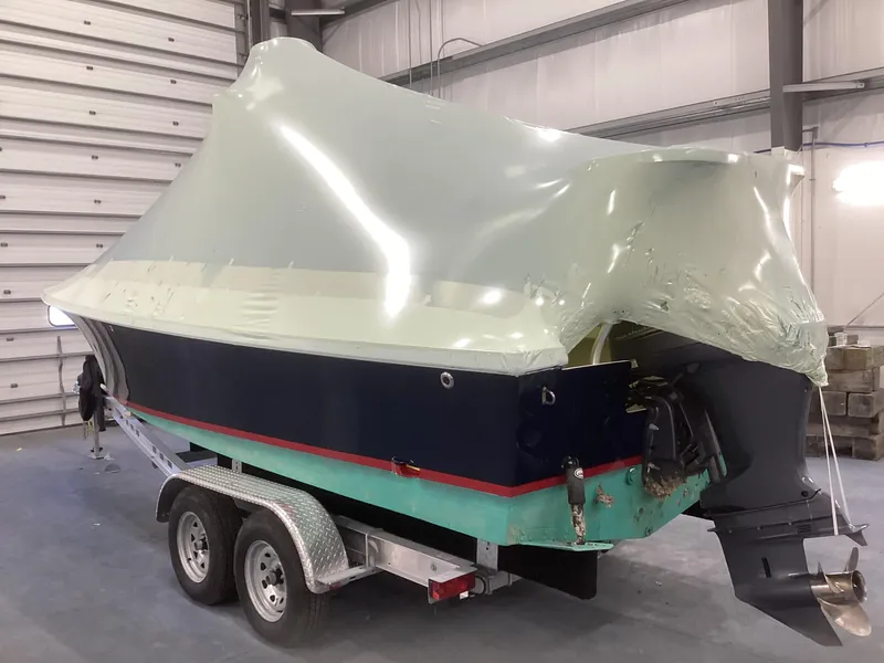 Slide: The Image of 2007 Jones Brothers 23 Cape Fisherman boat on trailer, partially covered in protective wrap. - 18