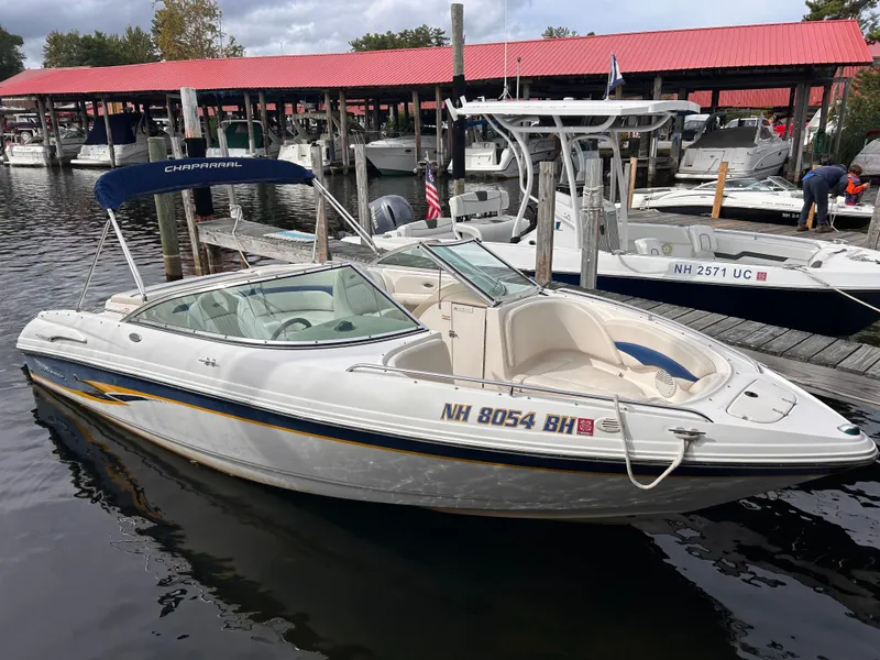 Slide: The Image of 2002 Chaparral 220 SSi boat docked at marina with red-roofed boathouses. - 0