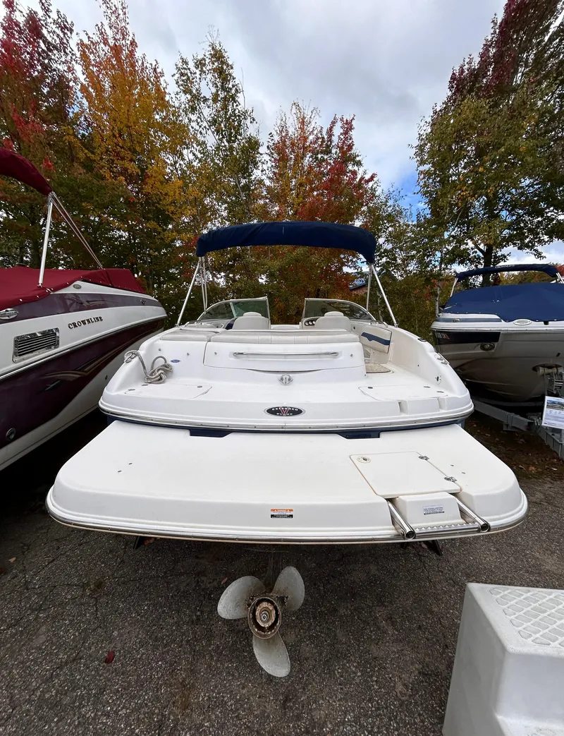 Slide: The Image of 2002 Chaparral 220 SSi boat with blue canopy, parked outdoors. - 11