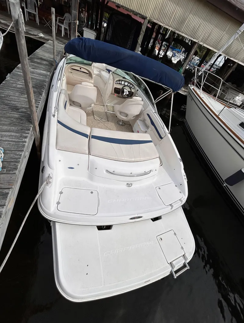 Slide: The Image of 2002 Chaparral 220 SSi boat docked, featuring spacious seating and a sleek design. - 12