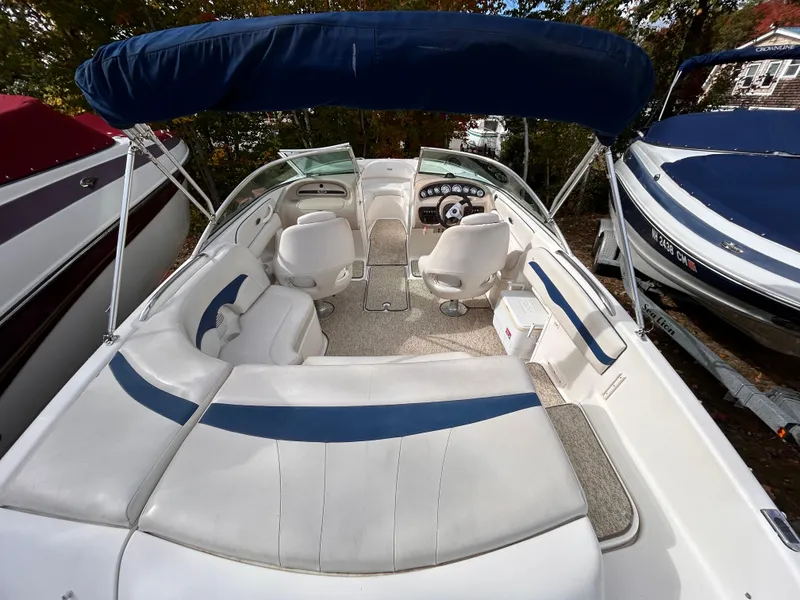 Slide: The Image of 2002 Chaparral 220 SSi boat interior with white and blue seating, under a blue canopy. - 19