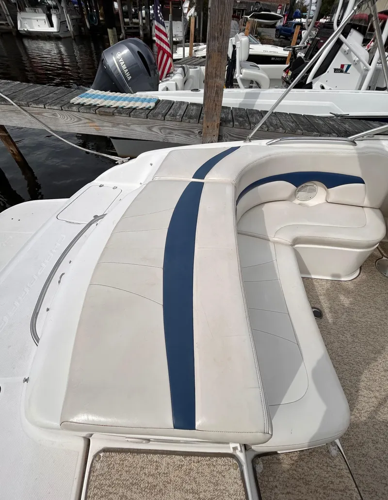 Slide: The Image of 2002 Chaparral 220 SSi boat with white and blue seating at a marina. - 21