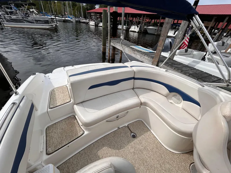 Slide: The Image of 2002 Chaparral 220 SSi boat interior with white and blue seating at a marina. - 25