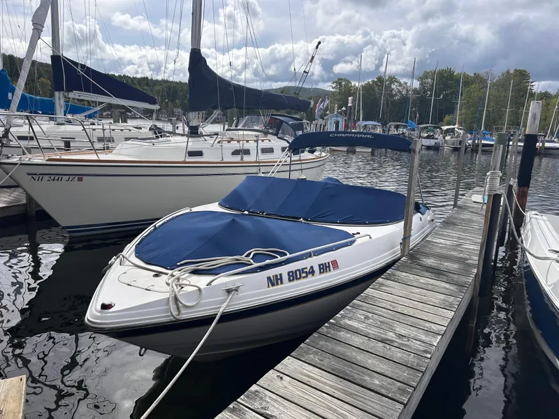 Slide: The Image of 2002 Chaparral 220 SSi boat docked at marina with blue cover. - 3