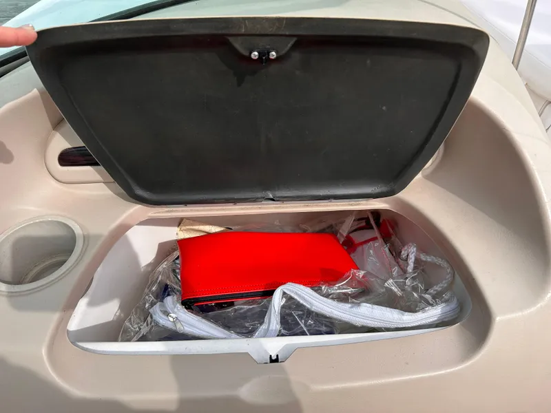 Slide: The Image of Open storage compartment in 2002 Chaparral 220 SSi boat with red and white items. - 42