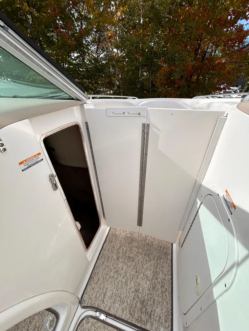 Slide: The Image of 2002 Chaparral 220 SSi boat interior with carpeted flooring and storage compartment. - 47